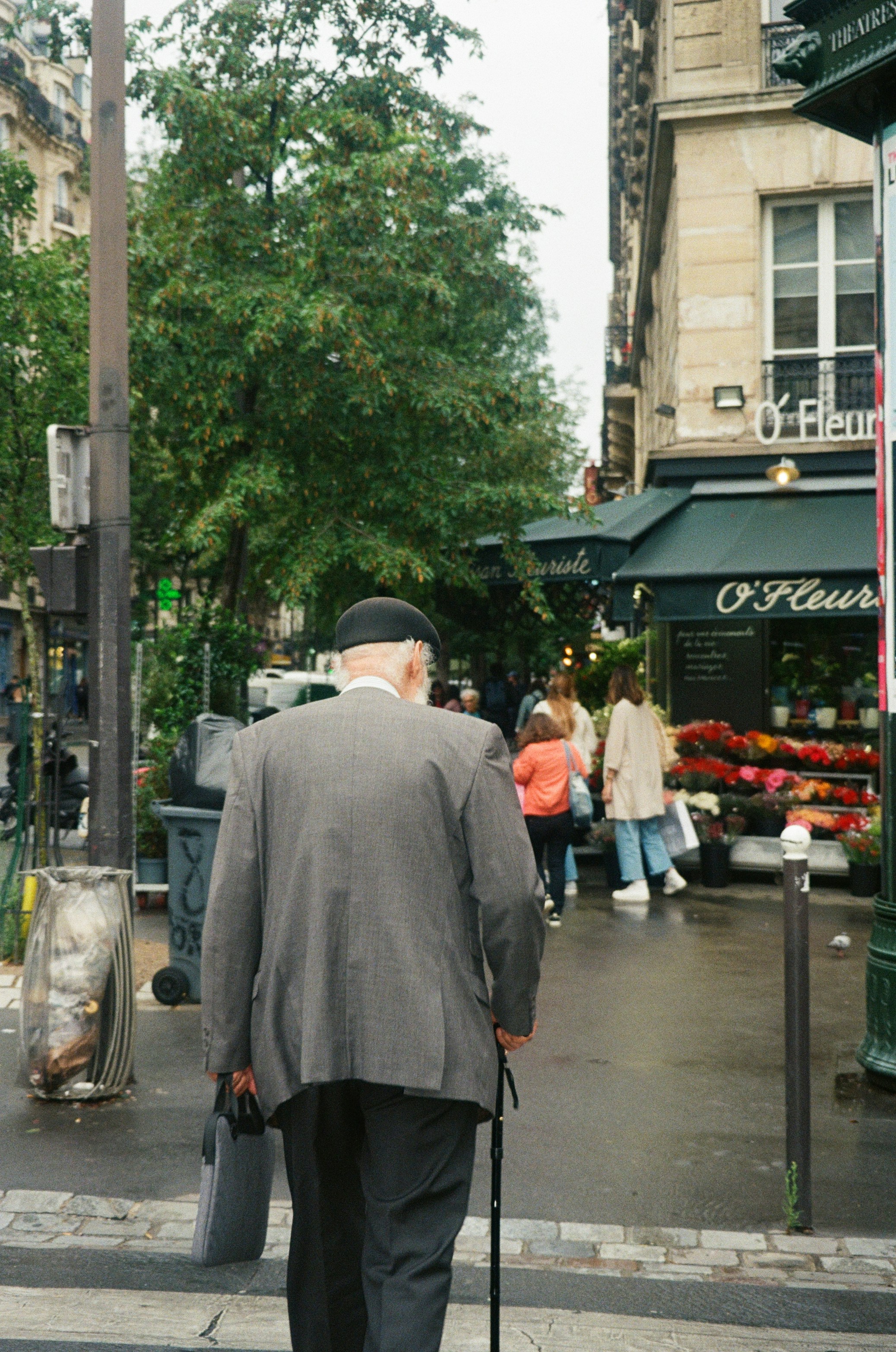 Un uomo che cammina per strada con un bastone