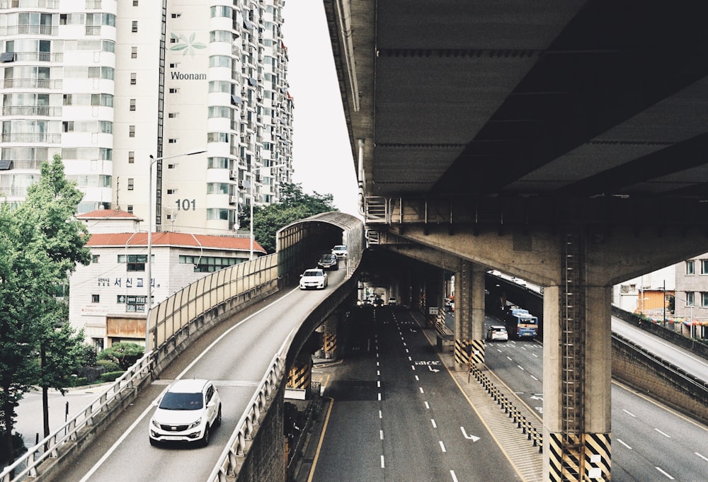 a car driving down a highway next to tall buildings