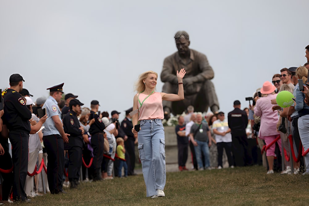 a woman is walking in front of a crowd of people