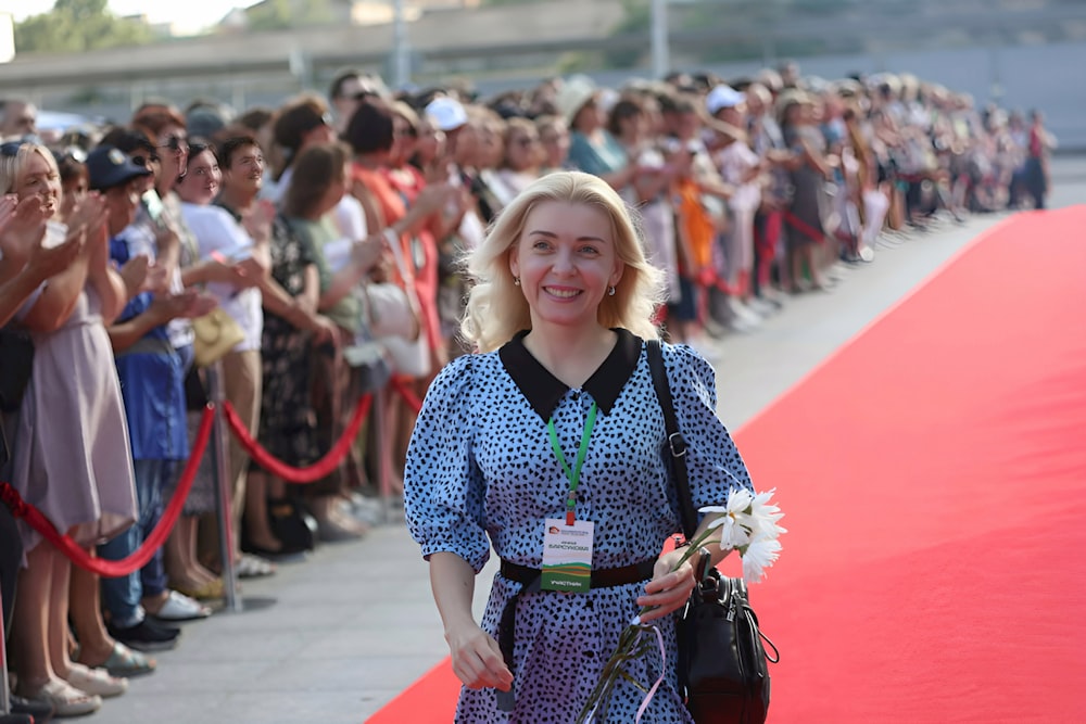 a woman is walking down a red carpet