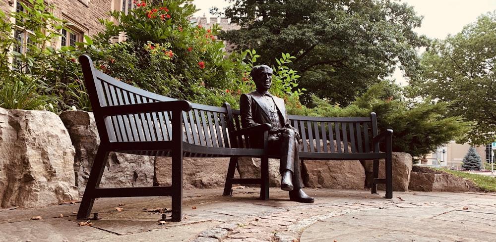 Una estatua de un hombre sentado en un banco
