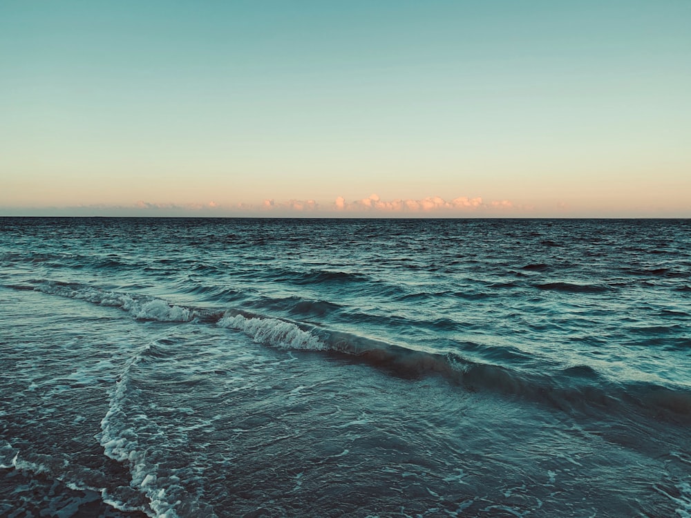 a view of a body of water with waves coming in