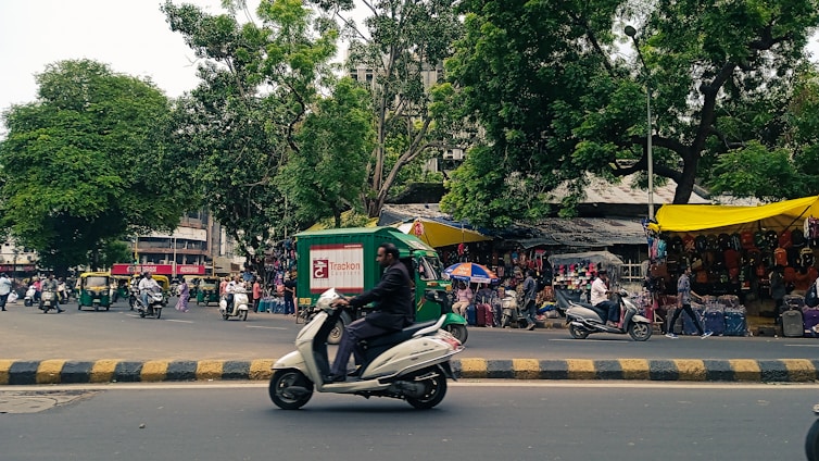 A vibrant street scene in Nagpur with locals engaging in daily activities under bright sunlight.