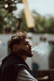 a man smoking a cigarette in a park
