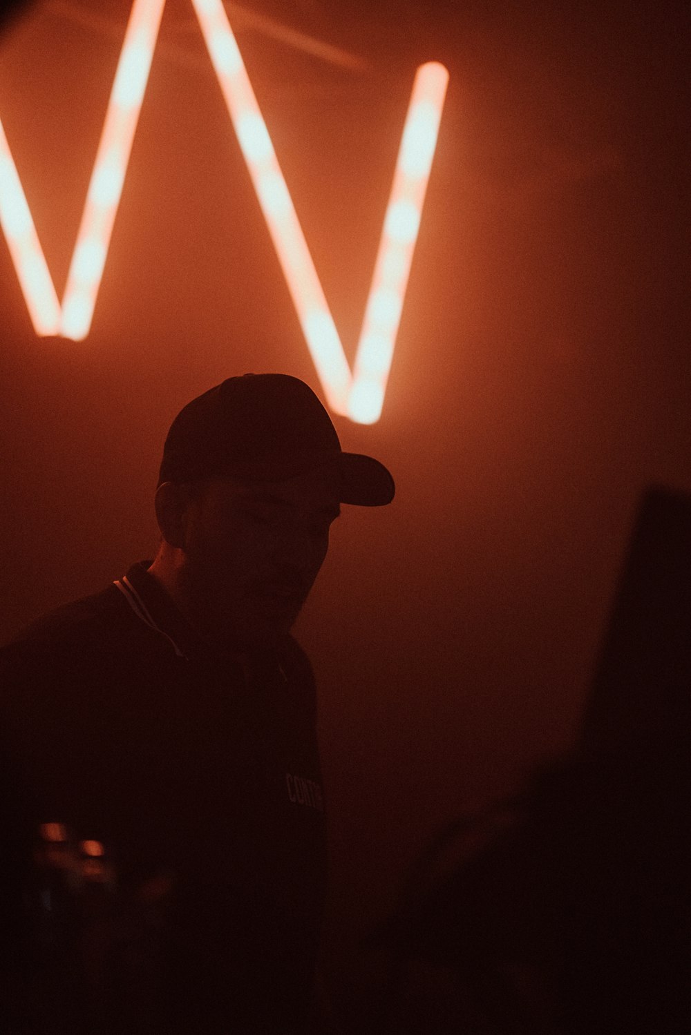 a man standing in front of a neon sign