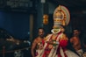 a man dressed in a colorful costume standing next to other men
