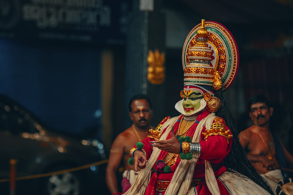 a man dressed in a colorful costume standing next to other men