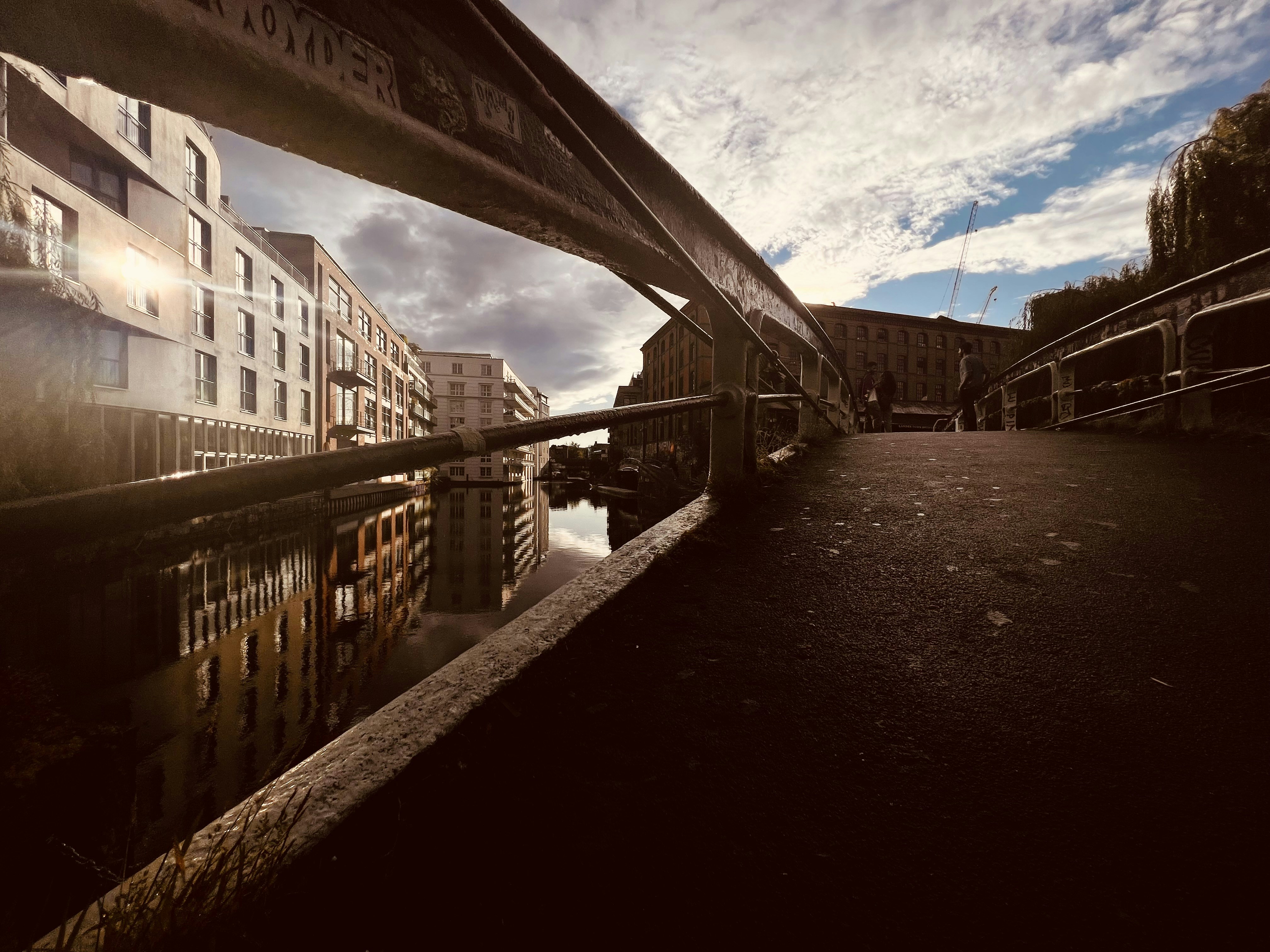 a bridge over a body of water with buildings in the background