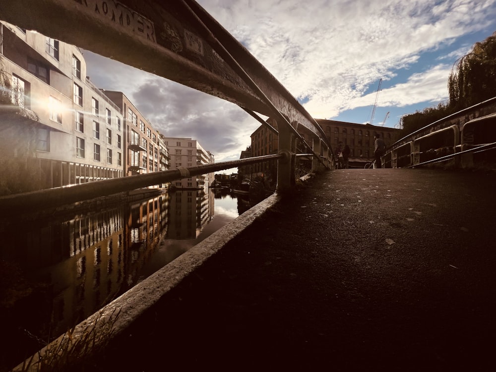 a bridge over a body of water with buildings in the background