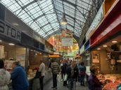 Vibrant modern food market bustling with customers and colorful stalls.