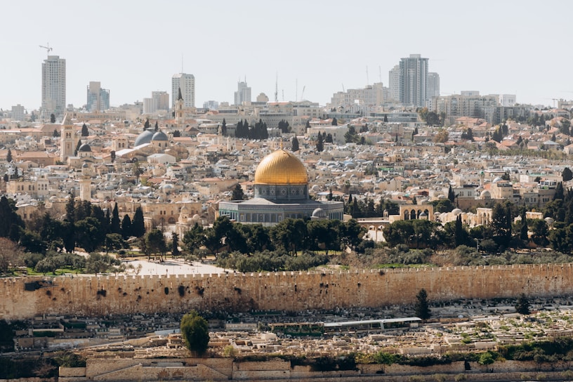 A stunning view of the Dome of the Rock glowing warmly at sunset.