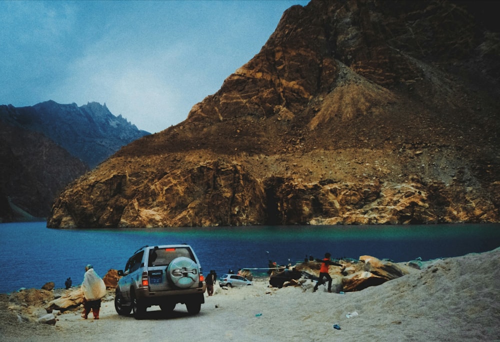 a group of people standing next to a parked car