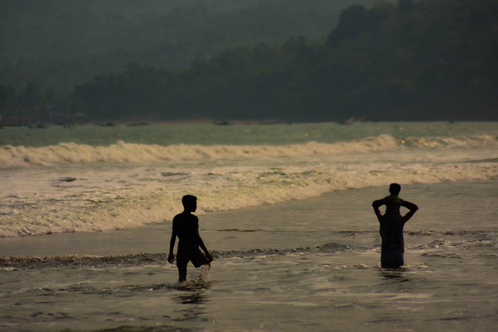 a couple of people that are standing in the water