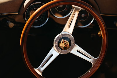 A close-up of the Porsche 911 dashboard illuminated at dusk, showcasing the classic gauges and steering wheel.