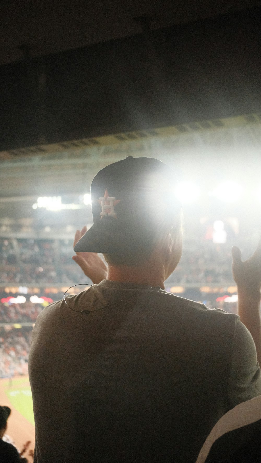 Un hombre con una gorra de béisbol parado frente a una multitud