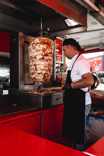 An elegant butcher expertly slicing meat in a stylish black and gold-themed mobile setup.