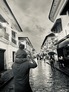 A family eagerly solving a puzzle while exploring a cobblestone street lined with charming shops.