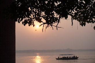 A serene boat gliding over calm waters of Chilika Lake during early morning.