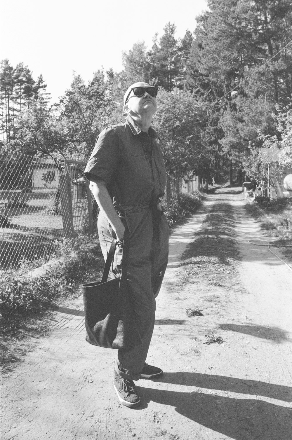 a black and white photo of a man carrying a bag