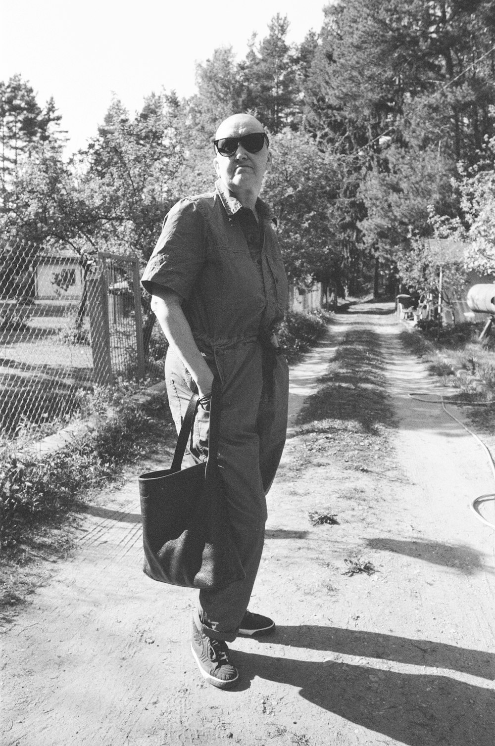 a black and white photo of a man carrying a bag