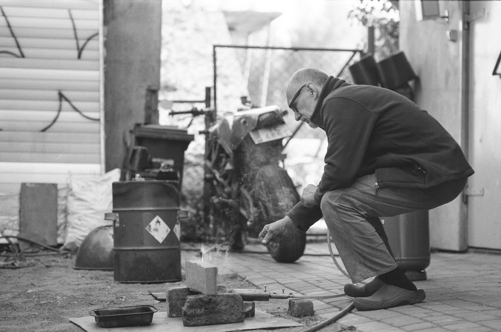 a man kneeling down next to a fire hydrant