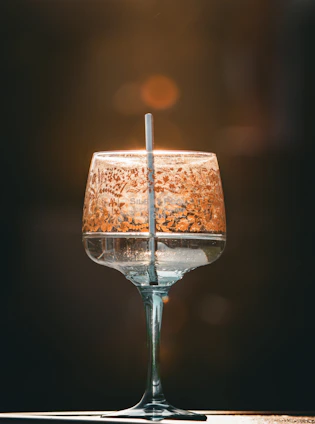 Close-up of a custom-printed glass with a delicate floral design glowing softly in warm light