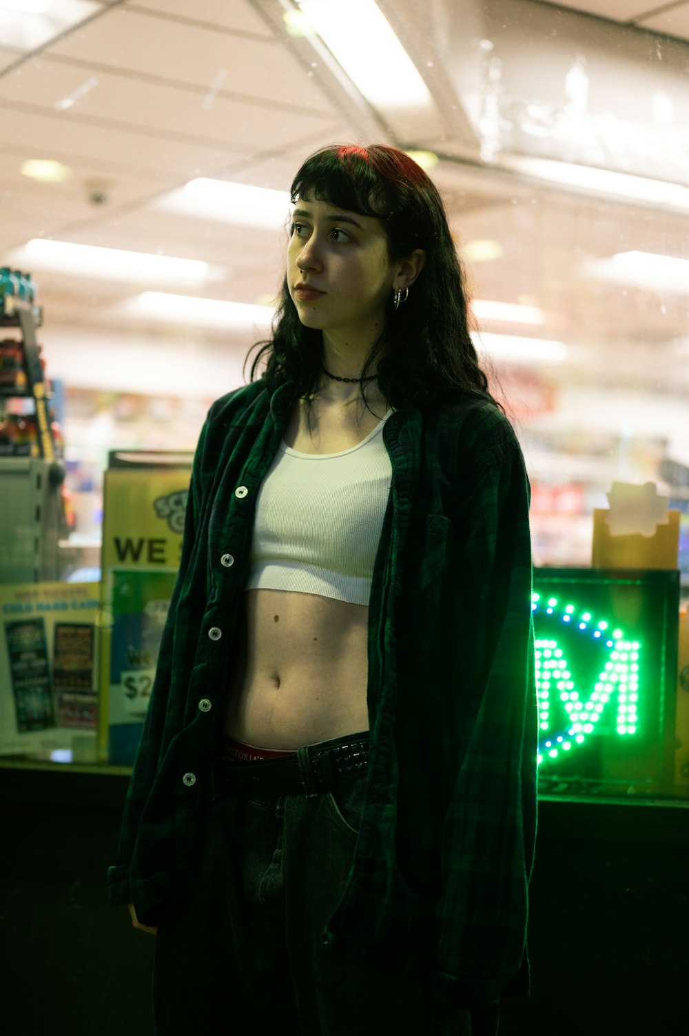 a woman standing in front of a neon sign