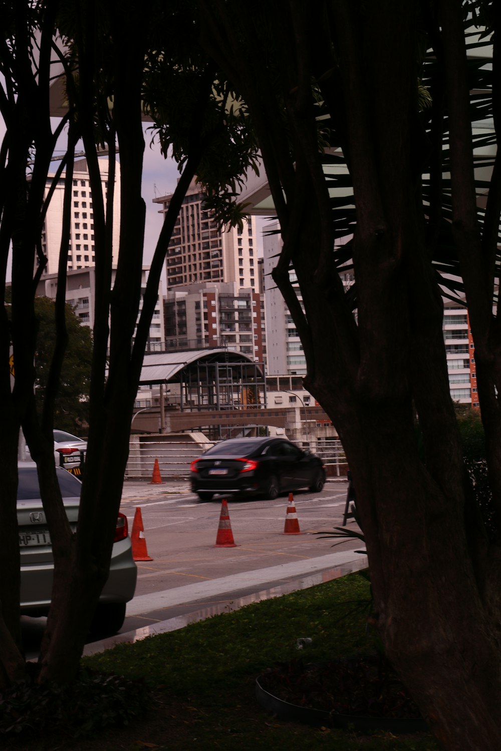 a black car driving down a street next to tall buildings