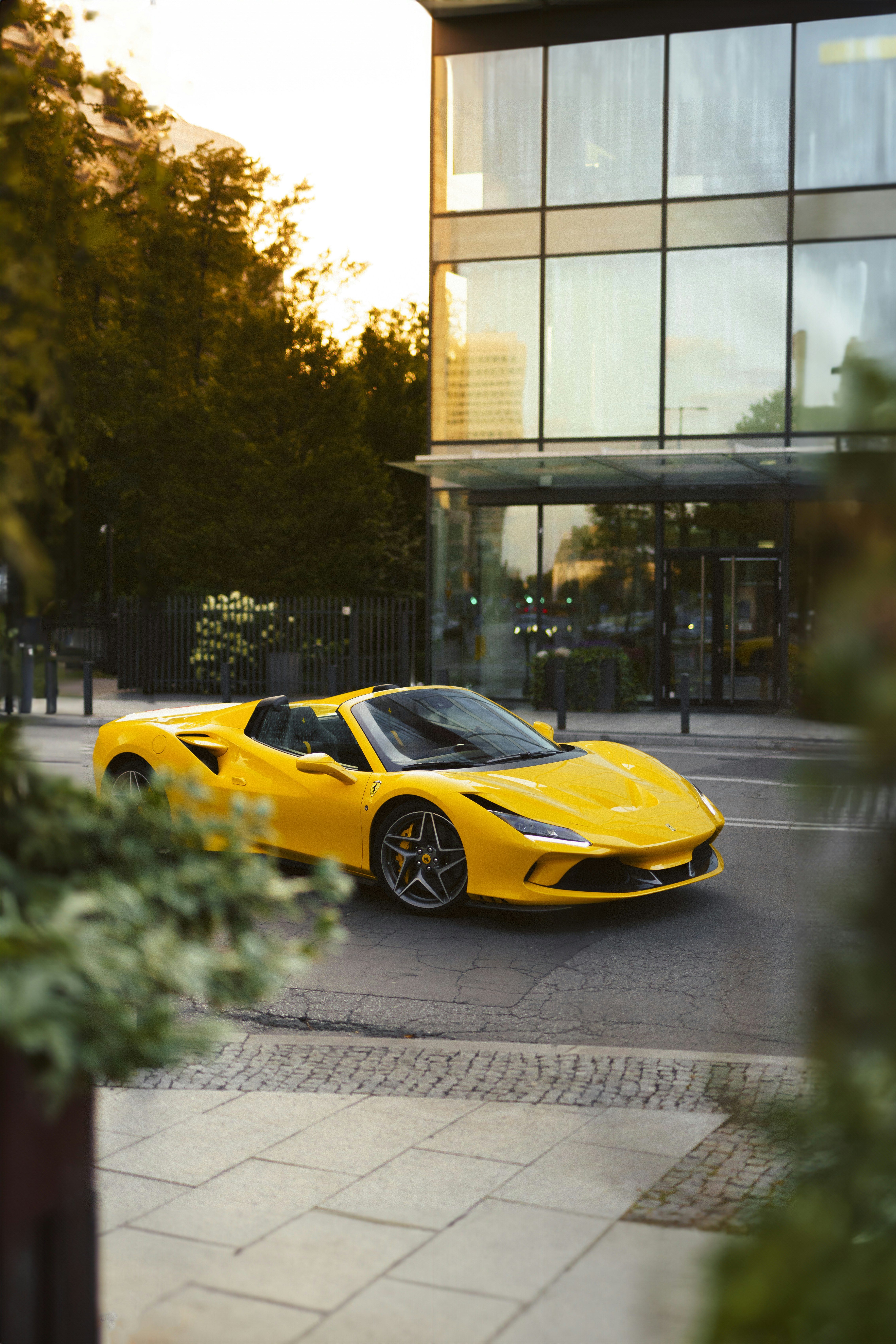 a yellow sports car parked in front of a building