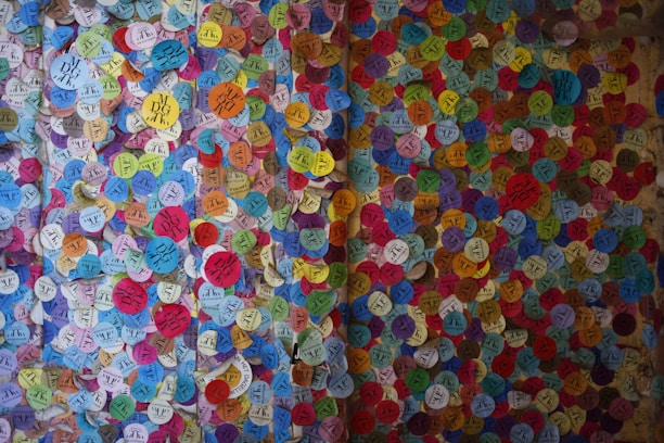 A vibrant assortment of colorful vinyl stickers spread out on a wooden table.