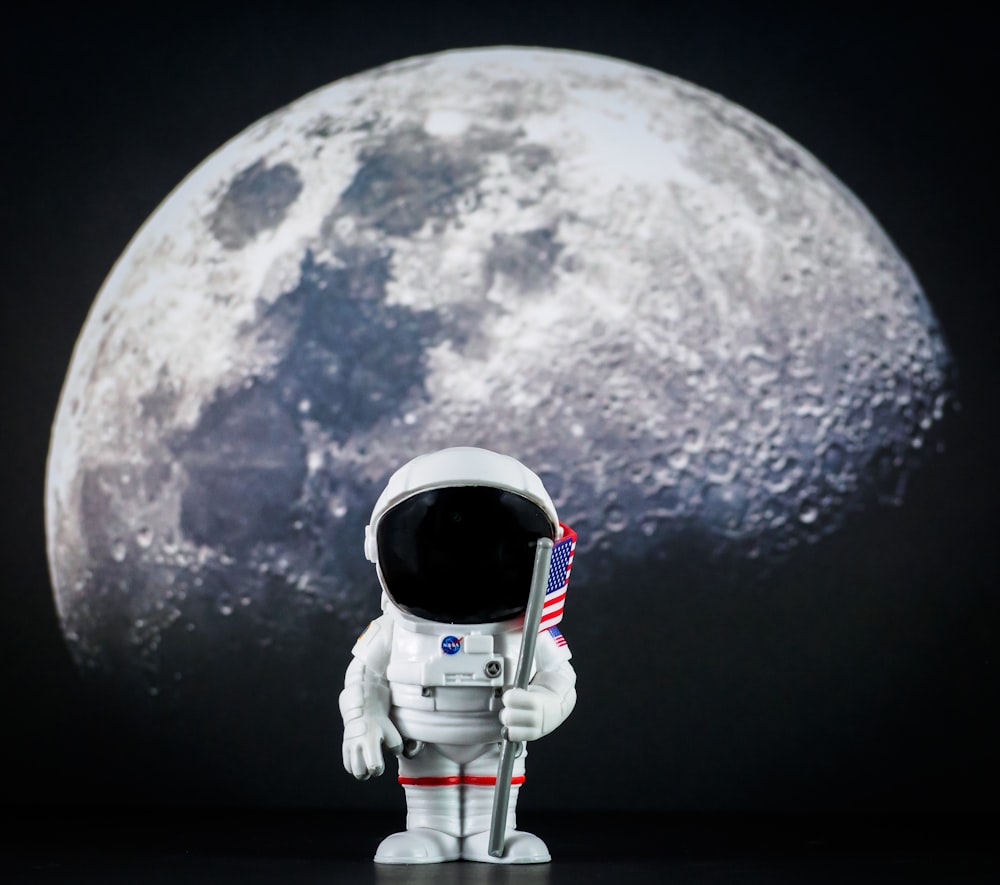 an astronaut holding a flag in front of a full moon