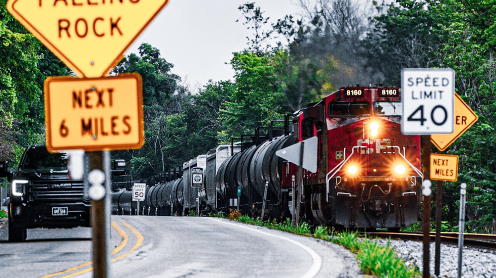 a train traveling down train tracks next to a forest