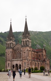 a group of people walking in front of a church
