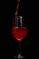 a glass of red wine being poured into it