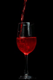a glass of red wine being poured into it