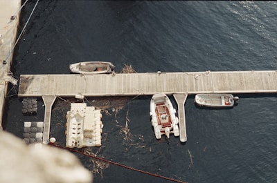 A wooden dock extending into the river with boats moored alongside.