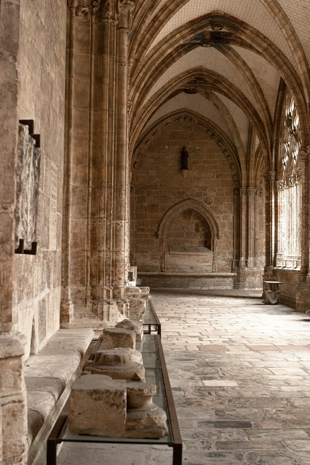 a long bench in a large building with stone floors