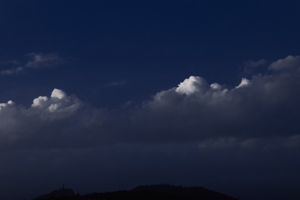 a plane is flying in the sky with clouds