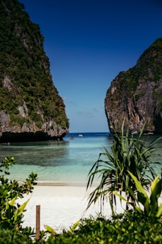 a sandy beach with two large mountains in the background