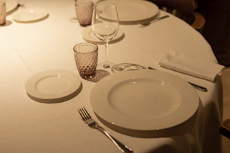 a table with a white table cloth and place settings