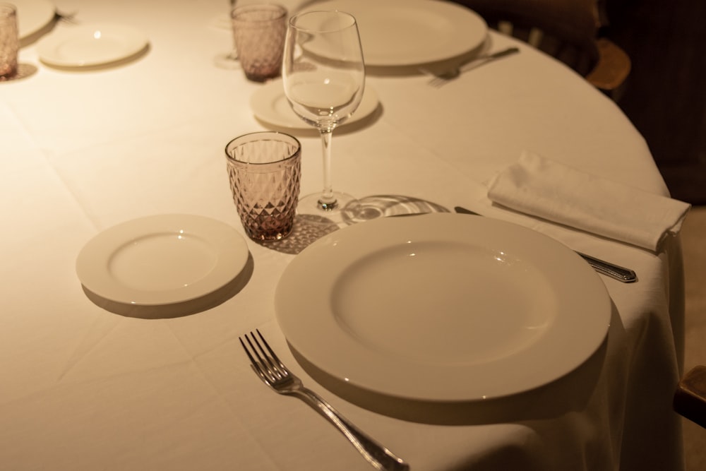 a table with a white table cloth and place settings