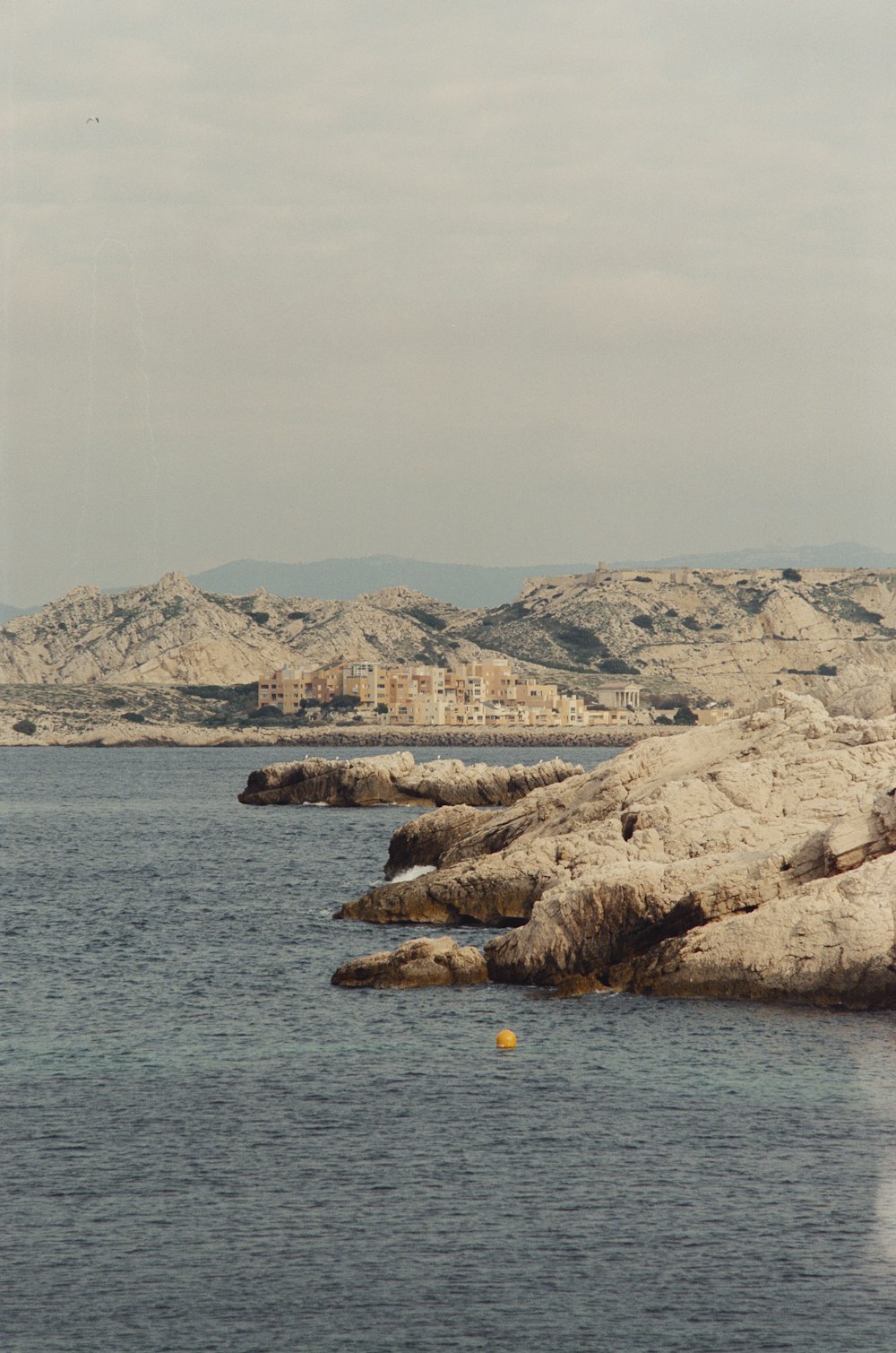 a body of water surrounded by mountains and buildings