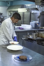 A chef demonstrating techniques in a well-equipped kitchen.