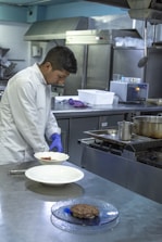 Chef preparing a meal in a clean, welcoming hotel kitchen.