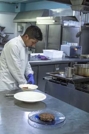 A professional chef preparing a dish in a modern kitchen.