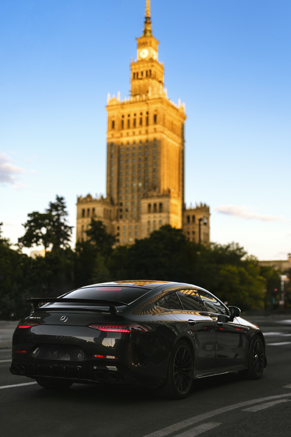 a black sports car driving down a city street