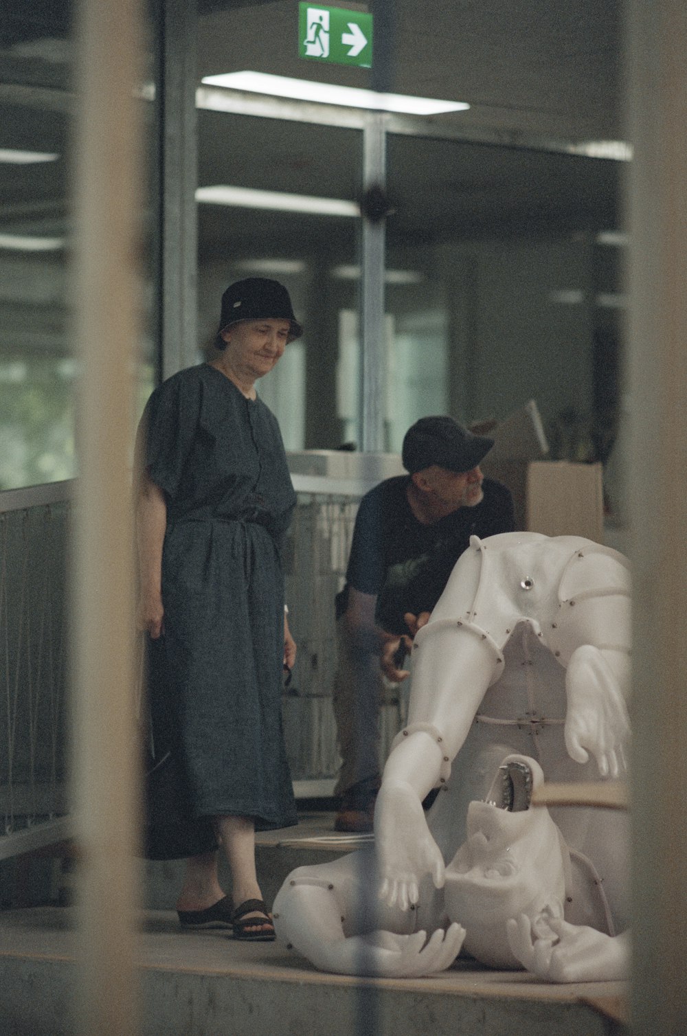 a woman standing next to a white statue