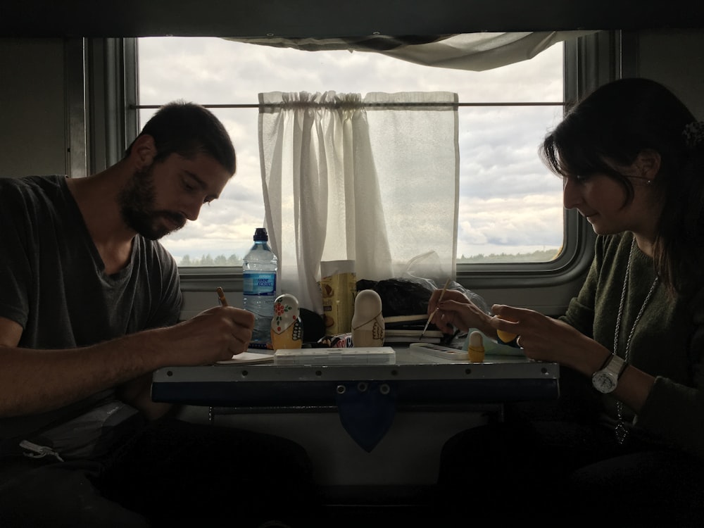 a man and a woman are sitting on a train