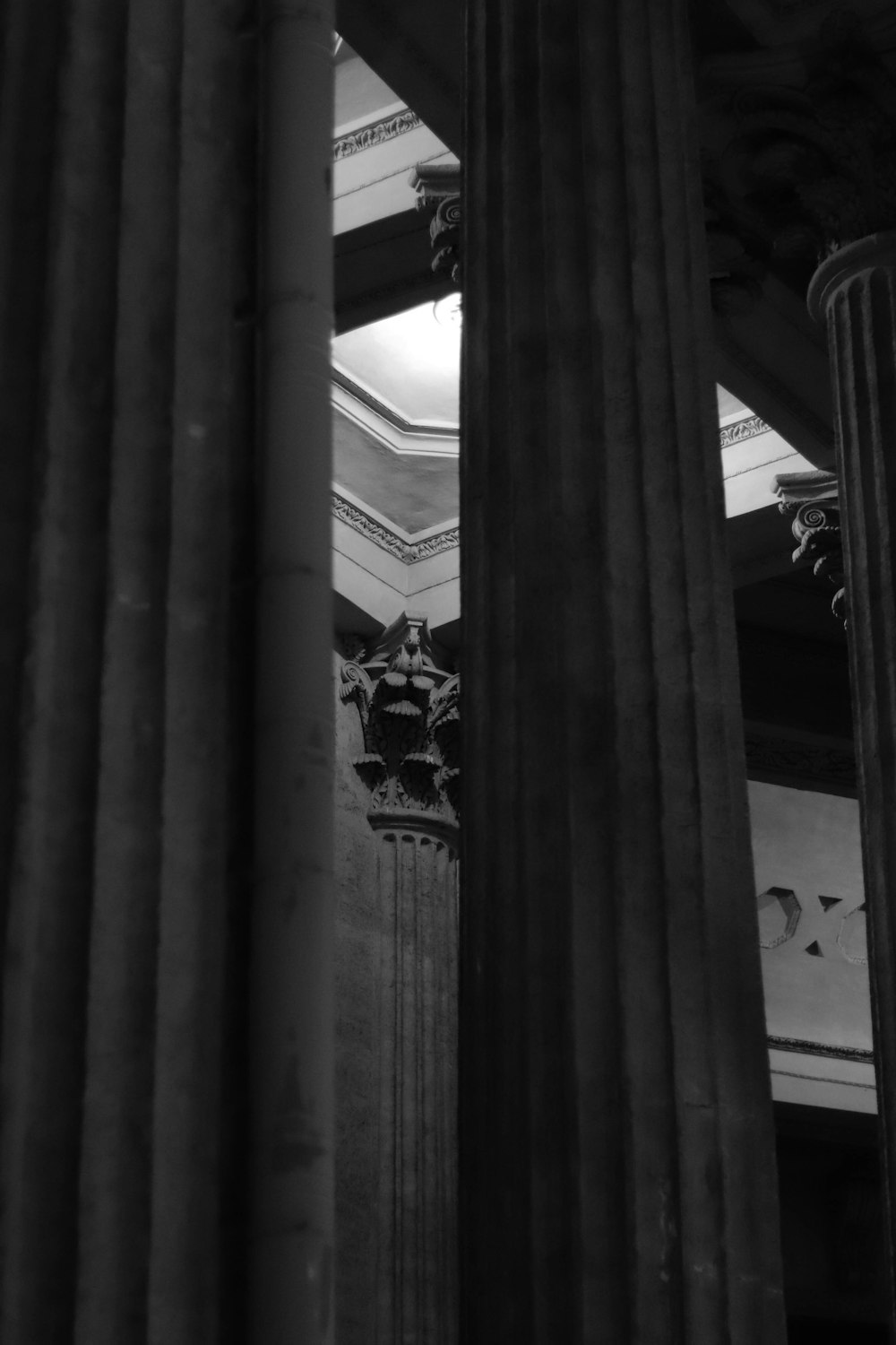 a black and white photo of columns and a clock