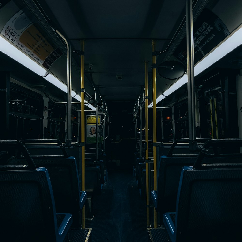 a dimly lit train car with blue seats
